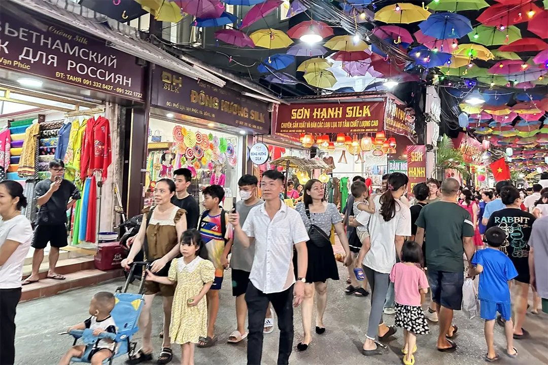 Du khách chụp ảnh selfie tại gian hàng thủ công mỹ nghệ làng lụa Vạn Phúc