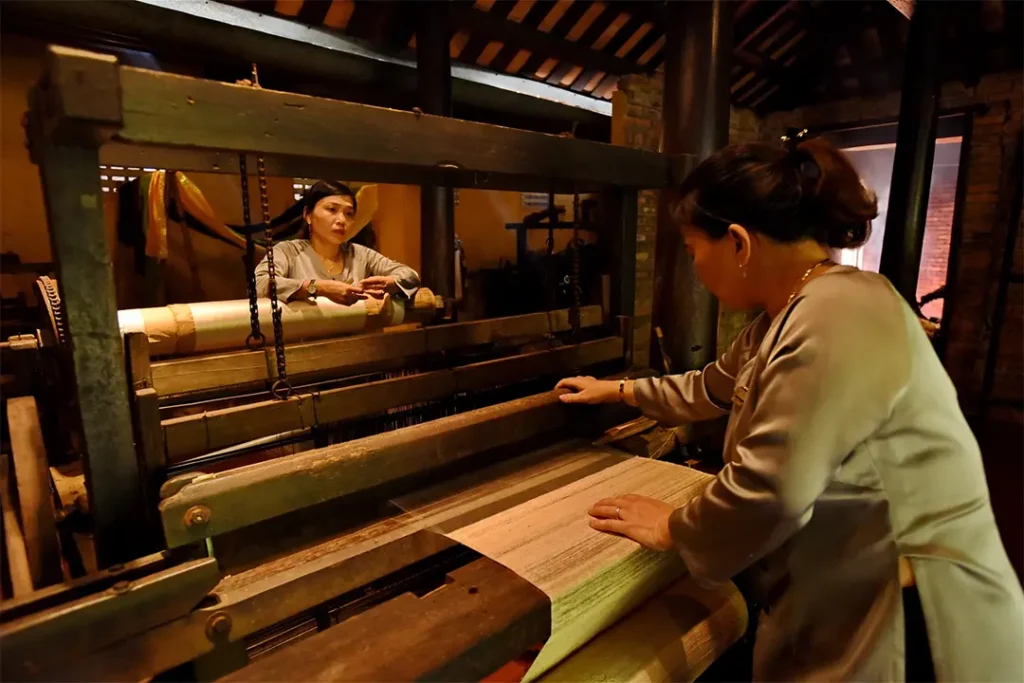 Nghệ nhân làng Vạn Phúc đang dệt lụa bằng khung cửi gỗ truyền thống